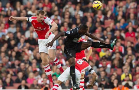 Arsenals Per Mertesacker, left, competes for the ball with Burnleys Marvin Sordell during their English Premier League soccer match at the Emirates stadium, London, Saturday, Nov. 1, 2014. (AP Photo/Tim Ireland)