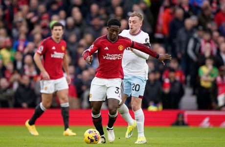Manchester United's Kobbie Mainoo controls the ball next to West Ham's Jarrod Bowen during the English Premier League soccer match between Manchester United and West Ham United at the Old Trafford stadium in Manchester, England, Sunday, Feb. 4, 2024. (AP Photo/Dave Thompson)