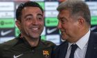 Barcelona's head coach Xavi Hernandez smiles next to Barcelona's president Joan Laporta during a press conference in Barcelona, Spain, Thursday, April 25, 2024. Coach Xavi Hernández will stay with Barcelona for another year after all. He has agreed with the club to finish his contract to 2025 after having decided to quit at the end of the season. (AP Photo/Emilio Morenatti)