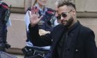 Former FC Barcelona player Neymar who now plays for Paris Saint-Germain waves on arrival at a court in Barcelona, Spain, Monday Oct. 17, 2022. Neymar returned to Spain Monday to face trial on fraud charges regarding his 2013 transfer from Santos to FC Barcelona. The Brazilian forward, his father, and the former executives of Barcelona and Santos are accused of hiding the true cost of his transfer with the alleged goal of cheating a private Brazilian company.(AP Photo/Joan Mateu Parra)