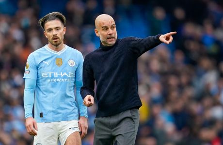 Manchester City's head coach Pep Guardiola, right, speaks with Manchester City's Jack Grealish at the end of the English Premier League soccer match between Manchester City and Arsenal at the Etihad stadium in Manchester, England, Sunday, March 31, 2024. (AP Photo/Dave Thompson)