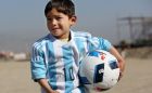 Murtaza Ahmadi, a five-year-old Afghan Lionel Messi fan poses for photograph, as he wears a donated shirt signed by Messi, in Kabul, Afghanistan, Friday, Feb. 26, 2016.  (AP Photo/Rahmat Gul)