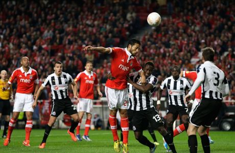 Benfica's Ezequiel Garay, from Argentina, center, is grabbed by Newcastle's Mapou Yanga-Mbiwa, from France,  during their Europa League quarterfinals, first leg, soccer match Thursday, April 4 2013, at Benfica's Luz stadium. Benfica defeated Newcastle 3-1. (AP Photo/Armando Franca)