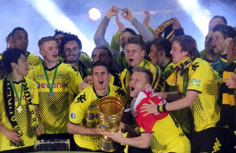 Dortmund's players celebrate with the trophy after winning the German cup " DFB Pokal " final football match Borussia Dortmund vs Bayern Munich at the Olympiastadion in Berlin on May 12, 2012. Dortmund defeated Munich 5-2.     AFP PHOTO / JOHN MACDOUGALL


RESTRICTIONS / EMBARGO - DFB LIMITS THE USE OF IMAGES ON THE INTERNET TO 15 PICTURES (NO VIDEO-LIKE SEQUENCES) DURING THE MATCH AND PROHIBITS MOBILE (MMS) USE DURING AND FOR FURTHER TWO HOURS AFTER THE MATCH. FOR MORE INFORMATION CONTACT DFB.JOHN MACDOUGALL/AFP/GettyImages
