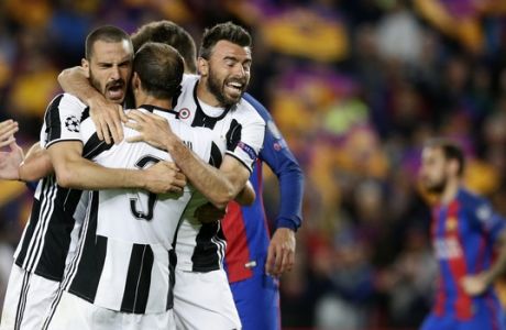 FILE - In this April 19, 2017 file photo Juventus' Leonardo Bonucci, left, celebrates with teammates Giorgio Chiellini, center, and Andrea Barzagli during the Champions League quarterfinal second leg soccer match between Barcelona and Juventus at Camp Nou stadium in Barcelona, Spain. Juventus will face Real Madrid in the Champions League final in Cardiff, Wales, on Saturday, June 3, 2017.  (AP Photo/Manu Fernandez, files)
