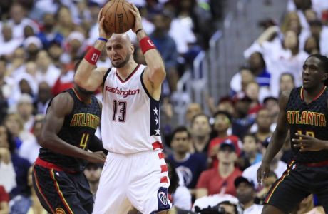 Washington Wizards center Marcin Gortat (13) grabs a rebound while Atlanta Hawks forward Paul Millsap, back left, and teammate Taurean Prince, right, defend during the second half in Game 1 of a first-round NBA basketball playoff series, in Washington, Sunday, April 16, 2017. The Wizards won 114-107. (AP Photo/Manuel Balce Ceneta)