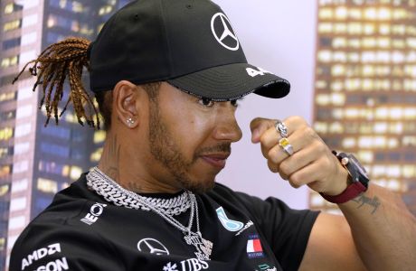 Mercedes driver Lewis Hamilton of Britain rubs his nose during a press conference at the Australian Formula One Grand Prix in Melbourne, Thursday, March 12, 2020. Six-time world champion Lewis Hamilton has questioned the wisdom of staging the season-opening Formula One Grand Prix while other sports are canceling events because of the spreading coronavirus. (AP Photo/Rick Rycroft)