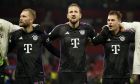 From left: Bayern's Raphael Guerreiro, Bayern's Harry Kane, and Bayern's Joshua Kimmich celebrate after the group A Champions League soccer match between Manchester United and Bayern Munich at the Old Trafford stadium in Manchester, England, Tuesday, Dec. 12, 2023. Bayern won 1-0. (AP Photo/Dave Thompson)