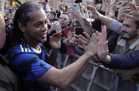 Brazilian soccer player Ronaldinho, left, is greeted by Russian fans after the friendly soccer match between former players from Russia's national team verses a team of 'Legends of world football', in St.Petersburg, Russia, Sunday, May 21, 2017. This match was a promotion of incoming 2017 Confederations Cup. (AP Photo/Dmitri Lovetsky)