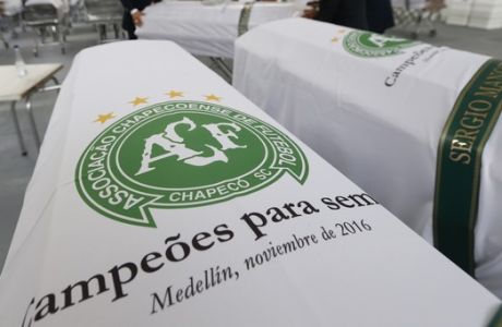 Funeral employees arrange caskets covered in white sheets with a Chapecoense soccer team logo that contain the remains of team members at the San Vicente funeral home in Medellin, Colombia, Friday, Dec. 2, 2016. The bodies of the Brazilian victims of this week's air tragedy will be repatriated later Friday to Chapeco, the hometown of the Brazilian soccer team. Members of the team and a group of journalists who perished on the flight were headed to the Copa Sudamericana finals when the plane ran out of fuel, crashing into the Andes outside Medellin.  (AP Photo/Fernando Vergara)