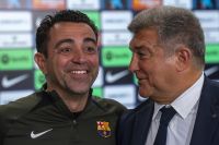 Barcelona's head coach Xavi Hernandez smiles next to Barcelona's president Joan Laporta during a press conference in Barcelona, Spain, Thursday, April 25, 2024. Coach Xavi Hernández will stay with Barcelona for another year after all. He has agreed with the club to finish his contract to 2025 after having decided to quit at the end of the season. (AP Photo/Emilio Morenatti)