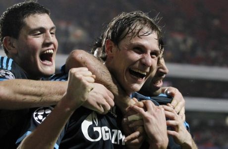 Schalke's  Benedikt Howedes celebrates with teammates Kyriakos Papadopoulos, left, and Raul Gonzalez, right,  after scoring their second goal against Benfica during their Champions League group B soccer match Tuesday, Dec. 7 2010, at Benfica's Luz stadium in Lisbon. (AP Photo/Armando Franca)