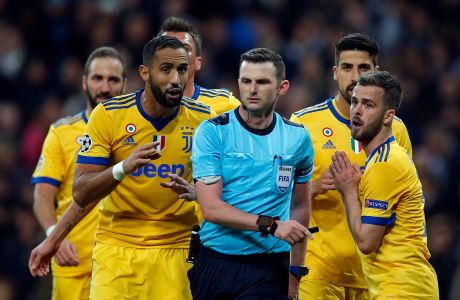 Juventus players complain to Referee Michael Oliver, center, for a penalty shot for Real, during a Champions League quarter-final, 2nd leg soccer match between Real Madrid and Juventus at the Santiago Bernabeu stadium in Madrid, Spain, Wednesday, April 11, 2018. (AP Photo/Paul White)