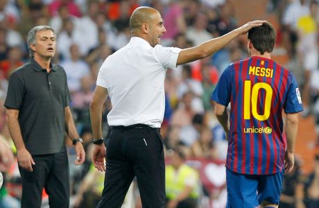 FC Barcelona's coach Josep Guardiola, center, celebrates with Lionel Messi from Argentina, right, besides Real Madrid's coach Jose Mourinho from Portugal, left, during a first leg Spanish Supercup soccer match at the Santiago Bernabeu stadium in Madrid, Spain, Sunday, Aug. 14, 2011. (AP Photo/Andres Kudacki)