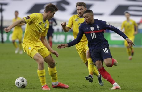 France's Kylian Mbappe, right, fights for the ball with Ukraine's Ilya Zabarnyi during the World Cup 2022 group D qualifying soccer match between France and Ukraine at the Start de de France stadium, in Saint Denis, north of Paris, Wednesday, March 24, 2021. (AP Photo/Thibault Camus)