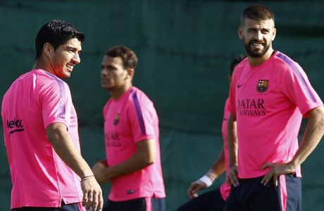 Barcelona's Uruguayan forward Luis Suarez (L) and Barcelona's defender Gerard Pique (R) take part in a training session at the Sports Center FC Barcelona Joan Gamper in Sant Joan Despi, near Barcelona, on August 15, 2014. Luis Suarez started training with his new Barcelona teammates today after getting the green light from the Court of Arbitration for Sport. AFP PHOTO / QUIQUE GARCIA