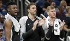 San Antonio Spurs players from left, Chimezie Metu, Pau Gasol, and Davis Bertans cheer on their teammates on the court during the second half of an NBA preseason basketball game against the Orlando Magic, Friday, Oct. 12, 2018, in Orlando, Fla. (AP Photo/John Raoux)