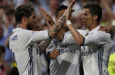 Real Madrid's Cristiano Ronaldo, right, celebrates with teammate Sergio Ramos, left, after scoring their side's third goal against Sevilla during the La Liga soccer match between Real Madrid and Sevilla at the Santiago Bernabeu stadium in Madrid, Sunday, May 14, 2017. (AP Photo/Francisco Seco)