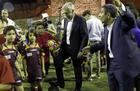 Italian soccer coach Carlo Ancelotti stand with Muslim, Christian and Jewish youth as part of the Assist for Peace, a coexistence group, in Jerusalem Monday, Oct. 2, 2017. Bayern Munich fired Ancelotti as coach on Thursday after the German team's heaviest Champions League group-stage defeat. (AP Photo/Mahmoud Illean)