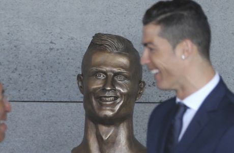 Portuguese president Marcelo Rebelo de Sousa, left, Portuguese Prime Minister Antonio Costa, 2nd left and Real Madrid's Cristiano Ronaldo stand next to a bust of the player at the Madeira international airport outside Funchal, the capital of Madeira island, Portugal, Wednesday March 29, 2017. Madeira International Airport has been renamed after local soccer star Cristiano Ronaldo on Wednesday during a ceremony, with family, at the airport outside his Funchal hometown. (AP Photo/Armando Franca)