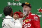 Mercedes driver Lewis Hamilton of Britain sprays champagne to Ferrari driver Sebastian Vettel of Germany after winning the Chinese Formula One Grand Prix at the Shanghai International Circuit in Shanghai on Sunday, April 14, 2019. Vettel finished third. (AP Photo/Andy Wong)