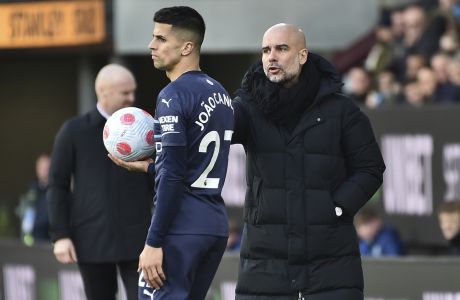Manchester City's head coach Pep Guardiola, right, gives directions to Manchester City's Joao Cancelo during the Premier League soccer match between Burnley and Manchester City at Turf Moor, in Burnley, England, Saturday, April 2, 2022. (AP Photo/Rui Vieira)