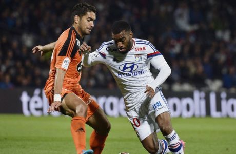 Lyon's French forward Alexandre Lacazette (R) vies for the ball  with Lorient's French defender Wesley Lautoa during the French L1 football match between Olympique Lyonnais (OL) and Lorient (FCL) on September 24, 2014, at the Gerland Stadium in Lyon, central-eastern France. AFP PHOTO / JEFF PACHOUD        (Photo credit should read JEFF PACHOUD/AFP/Getty Images)