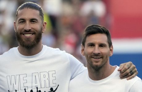 PSG's Lionel Messi, right, and PSG's Sergio Ramos smile during players presentation before the French League One soccer match between Paris Saint Germain and Strasbourg, at the Parc des Princes stadium in Paris, Saturday, Aug. 14, 2021. (AP Photo/Francois Mori)