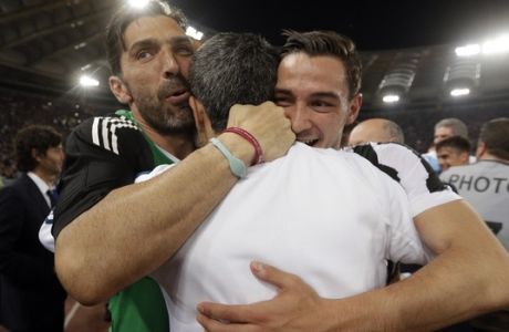 Juventus goalkeeper Gianluigi Buffon, left, celebrates with teammate Mattie De Sciglio at the end of the Serie A soccer match between Roma and Juventus, at the Rome Olympic stadium, Sunday, May 13, 2018. The match ended in a scoreless draw and Juventus won record-extending seventh straight Serie A title. (AP Photo/Gregorio Borgia)