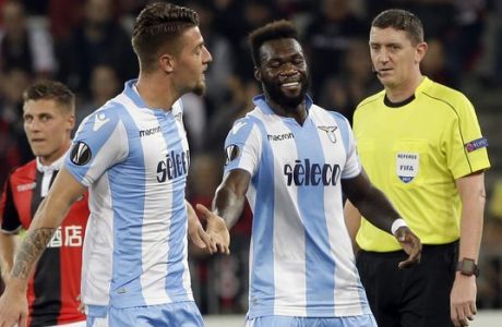 Lazio's Sergej Milinkovic-Savic, left, celebrates his side's 2nd goal with his teammate Felipe Caicedo while referee Craig Thomson from Scotland looks on during a Europa League group K soccer match between OGC Nice and Lazio at the Allianz Riviera stadium in Nice, French Riviera, Thursday, Oct. 19, 2017 (AP Photo/Claude Paris)