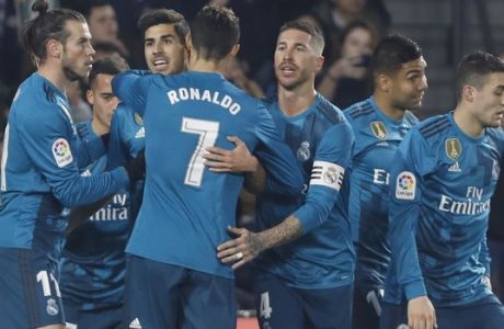 Real Madrid's Asensio, second left, celebrates with teammates after scoring against Betis during La Liga soccer match between Betis and Real Madrid at the Villamarin stadium, in Seville, Spain on Sunday, Feb. 18, 2018. (AP Photo/Miguel Morenatti)