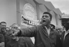 Cassius Clay, young heavyweight fighter, thrusts his fist out, Feb. 19, 1964, as he tells a crowd at Surfside, Fla., how he'll hit champion Sonny Liston in their upcoming bout at Miami Beach.  Clay and his followers paid an unexpected visit to Liston's Surfside camp.  (AP Photo/Harry Harris)