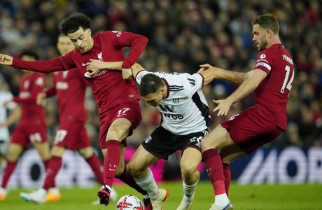 Fulham's Joao Palhinha, center, challenges for the ball with Liverpool's Curtis Jones, left, and his teammate Jordan Henderson during the English Premier League soccer match between Liverpool and Fulham, at Anfield Stadium, Liverpool, England, Wednesday, May 3, 2023. (AP Photo/Jon Super)