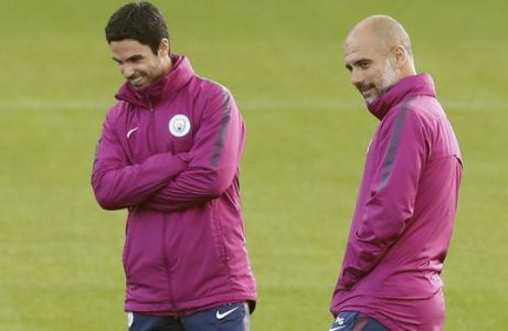 Manchester City manager Pep Guardiola, right, and coach Mikel Arteta, centre, during a training session at the City Football Academy, Manchester, England, Tuesday, Sept. 12, 2017.  (Martin Rickett/PA via AP)