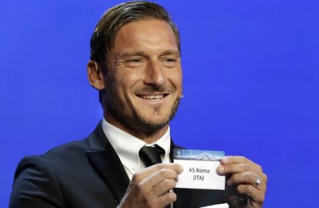 Former Italian player Francesco Totti shows the name ofAS Roma, who will play in Group C during the UEFA Champions League draw at the Grimaldi Forum, in Monaco, Thursday, Aug. 24, 2017. (AP Photo/Claude Paris)