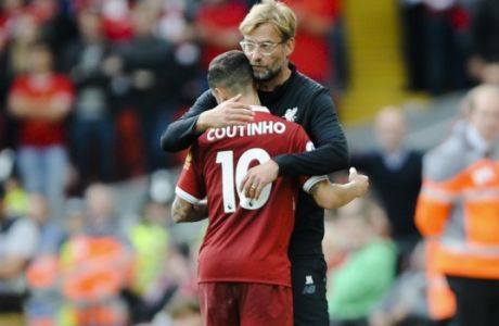 Liverpool coach Juergen Klopp, right, embraces Liverpool's player Philippe Coutinho during the English Premier League soccer match between Liverpool and Manchester United at Anfield, Liverpool, England, Saturday, Oct. 14, 2017. (AP Photo/Rui Vieira)