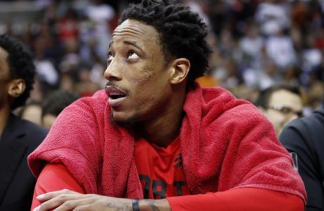 Toronto Raptors guard DeMar DeRozan, right, watches the overhead screen in the first half of Game 6 of an NBA basketball first-round playoff series against the Washington Wizards, Friday, April 27, 2018, in Washington. (AP Photo/Alex Brandon)
