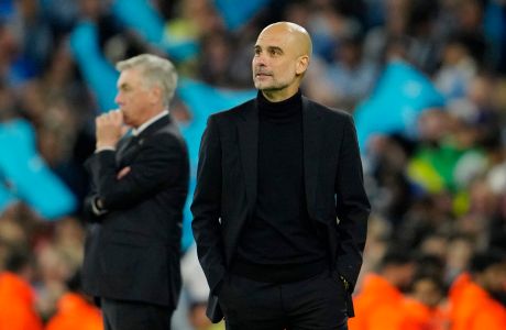 Manchester City's head coach Pep Guardiola and Real Madrid's head coach Carlo Ancelotti, left, stand by the touchline during the last minutes of the Champions League semifinal second leg soccer match between Manchester City and Real Madrid at Etihad stadium in Manchester, England, Wednesday, May 17, 2023. Manchester City won 4-0. (AP Photo/Jon Super)