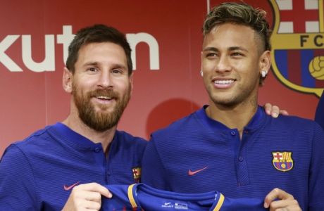 FILE - In this July 13, 2017, file photo, FC Barcelona's Lionel Messi, left, and Neymar pose with their new jersey during a press conference in Tokyo.   Neymar is not for sale, according to Barcelona President Josep Bartomeu. Speaking Thursday, July 20, 2017 during an interview at The Associated Press, Bartomeu said: "He is not on the market." (AP Photo/Eugene Hoshiko, File)
