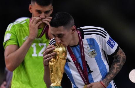 Argentina's Angel Di Maria kisses the trophy after the World Cup final soccer match between Argentina and France at the Lusail Stadium in Lusail, Qatar, Sunday, Dec.18, 2022. (AP Photo/Manu Fernandez)