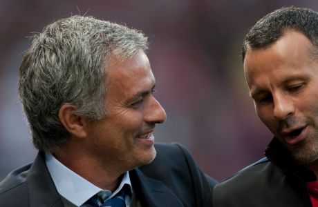 Chelsea's manager Jose Mourinho, left, speaks to Manchester United's Ryan Giggs as they make their way down the touchline before their English Premier League soccer match at Old Trafford Stadium, Manchester, England, Monday Aug. 26, 2013. (AP Photo/Jon Super)