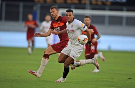 Sevilla's Diego Carlos, right, and Roma's Edin Dzeko, vie for the ball during the Europa League, round of 16 soccer match between Roma and Sevilla, at the Schauinsland-Reisen-Arena in Duisburg, Germany, Thursday, Aug. 6, 2020. (Wolfgang Rattay/Pool Photo via AP)