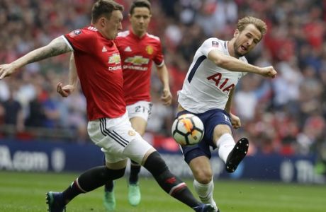 Tottenham's Harry Kane shoots the ball past Manchester United's Phil Jones, left, during the English FA Cup semifinal soccer match between Manchester United and Tottenham Hotspur at Wembley stadium in London, Saturday, April 21, 2018. (AP Photo/Kirsty Wigglesworth)