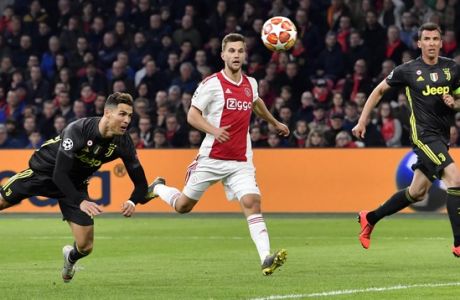 Juventus' Cristiano Ronaldo, left, scores his side's opening goal during the Champions League quarterfinal, first leg, soccer match between Ajax and Juventus at the Johan Cruyff ArenA in Amsterdam, Netherlands, Wednesday, April 10, 2019. (AP Photo/Martin Meissner)