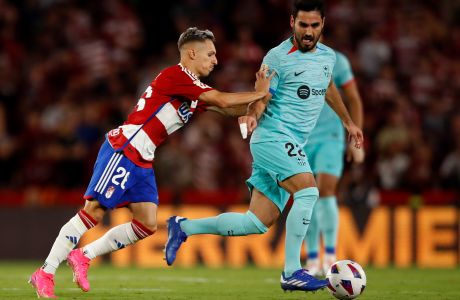 FILE - Granada's Bryan Zaragoza pushes Barcelona's Ilkay Gundogan during a Spanish La Liga soccer match between Granada and Barcelona at Los Carmanes Stadium in Granada, Spain, on Oct. 8, 2023. Bayern Munich is signing Spain winger Bryan Zaragoza from struggling La Liga team Granada, with the deal set to go through in July. The German champion said Wednesday Dec. 6, 2023 that the 22-year-old Zaragoza would sign a five-year contract running through to 2029 when he joins Bayern at the end of the season. (AP Photo/Fermin Rodriguez, File)