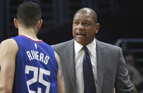 Los Angeles Clippers head coach Doc Rivers talks with guard Austin Rivers (25) during an NBA basketball game against the Denver Nuggets, Saturday, April 7, 2018, in Los Angeles. (AP Photo/Michael Owen Baker)