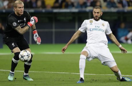 Real Madrid's Karim Benzema, right, scores against Liverpool goalkeeper Loris Karius during the Champions League Final soccer match between Real Madrid and Liverpool at the Olimpiyskiy Stadium in Kiev, Ukraine, Saturday, May 26, 2018. (AP Photo/Sergei Grits)