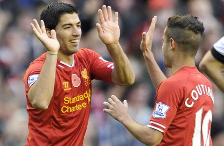 Liverpool's Luis Suarez, right, celebrates after scoring the third goal of the game with teammate Philippe Coutinho during their English Premier League soccer match against Fulham at Anfield in Liverpool, England, Saturday, Nov. 9, 2013. (AP Photo/Clint Hughes)