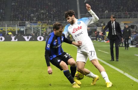 Inter Milan's Nicolo Barella, left, and Napoli's Khvicha Kvaratskhelia fight for the ball as the Inter Milan's head coach Simone Inzaghi, rear right, gives reacts during a Serie A soccer match between Inter Milan and Napoli at the San Siro stadium in Milan, Italy, Wednesday, Jan. 4, 2023. (AP Photo/Luca Bruno)