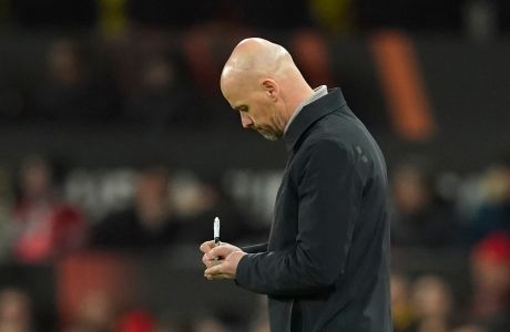 Manchester United's head coach Erik ten Hag writes down a note during the Europa League playoff second leg soccer match between Manchester United and Barcelona at Old Trafford stadium in Manchester, England, Thursday, Feb. 23, 2023. (AP Photo/Dave Thompson)